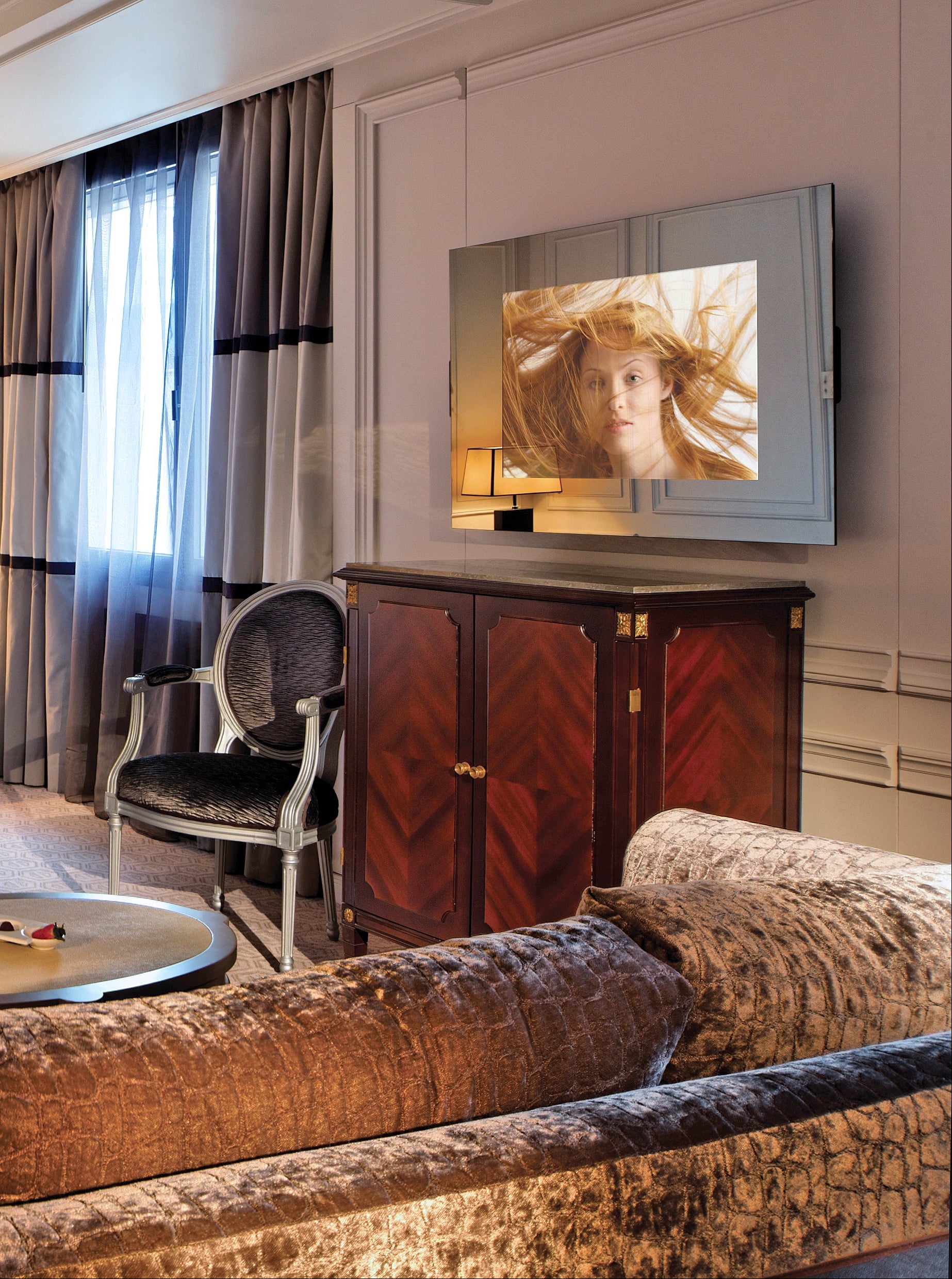 Luxurious bedroom with a bed, TV, and sitting area.